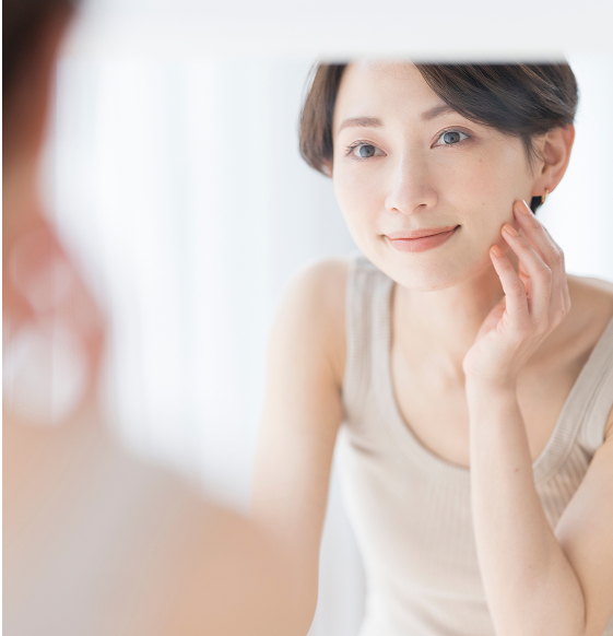 女性が鏡を見て肌を確認している様子